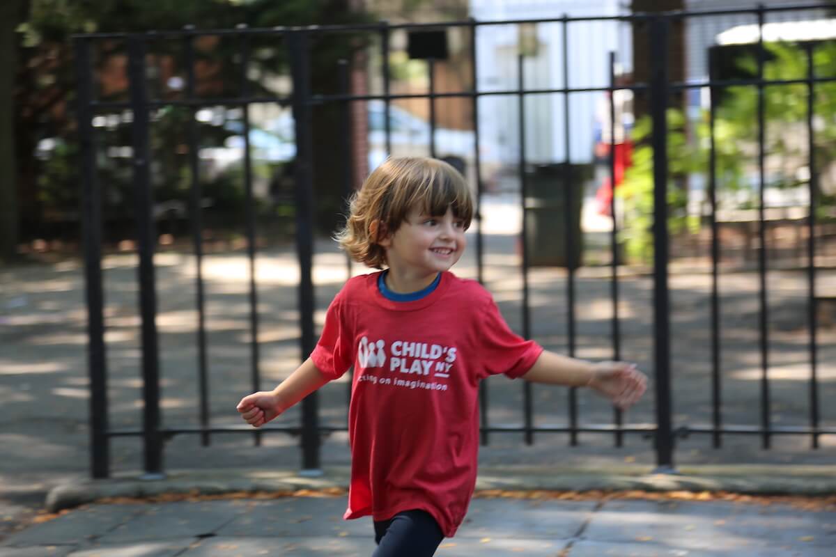 Child playing in park in camp t-shirt